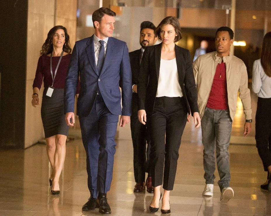 Scott Foley e Lauren Cohan andando em cena de whiskey cavalier da warner. No Brasil, a série é intitulada Jogo de Espiões