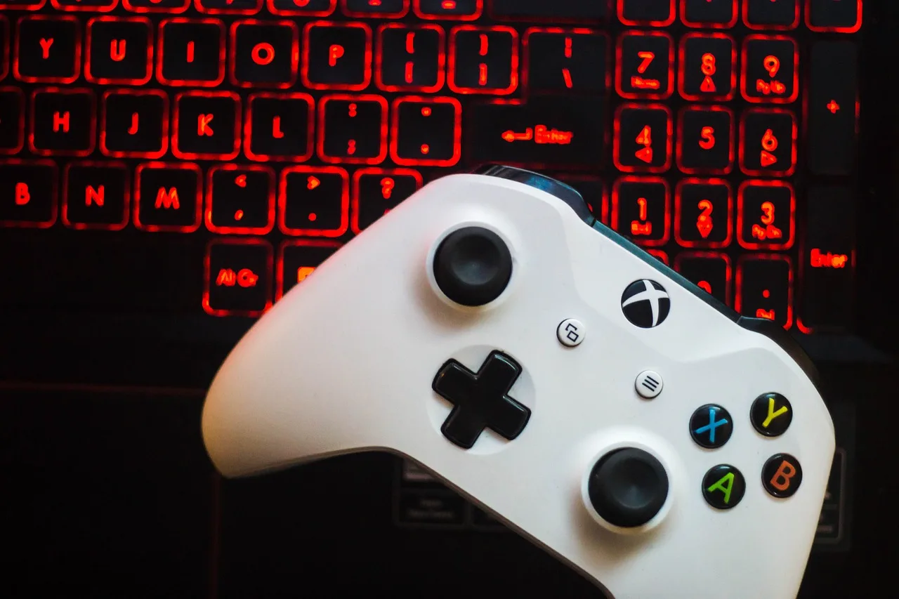 controle de um console xbox com um teclado ao fundo